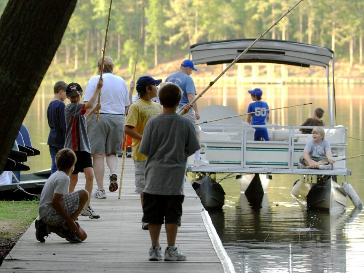 kids prepare to go fishing on thepontoon boat with adults