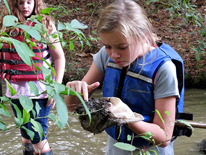 girls examining soil from the lake's edge.