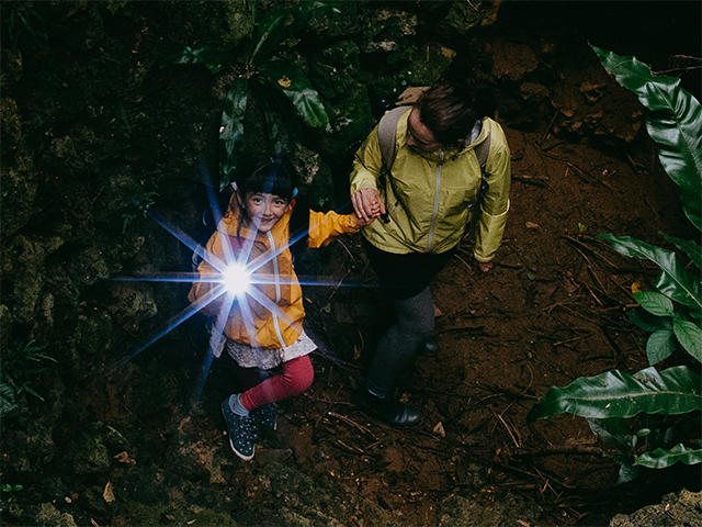adult and child with a flashlight on a night hike
