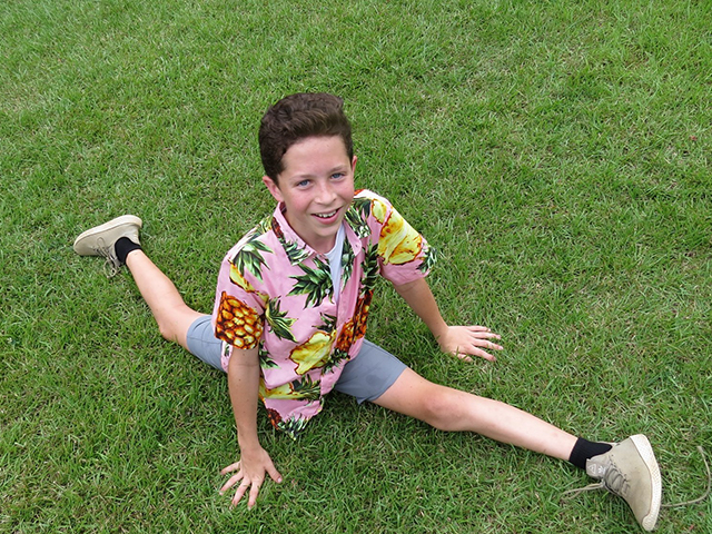 camper displaying the gymnastic talent of performing a split on the grass